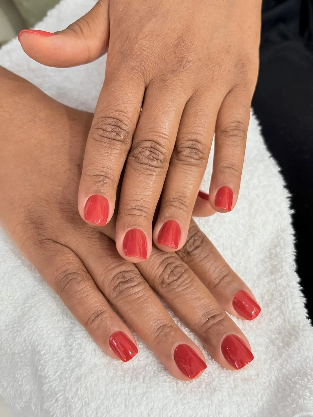 Mãos com esmalte vermelho após manicure